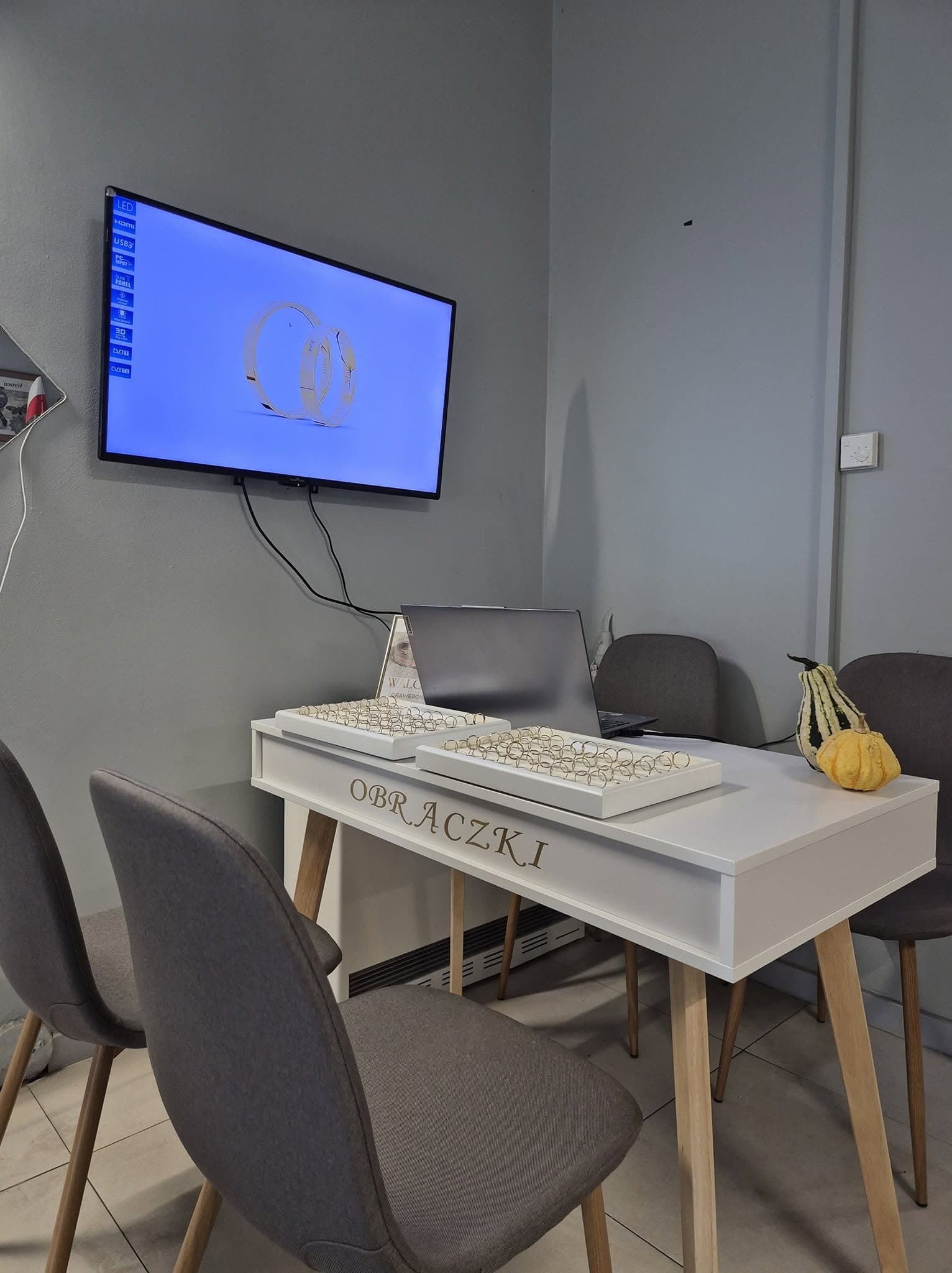 Kącik obrączkowy w salonie — stolik z ekspozytorami obrączek i ekran z wizualizacją graweru, showroom obrączek ślubnych Zgierz, Jubilerstwo Walczak